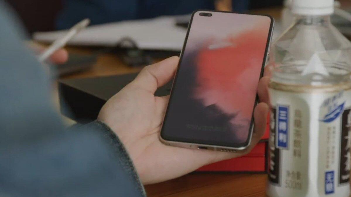 Пользователь держит смартфон Xiaomi с экраном на закате