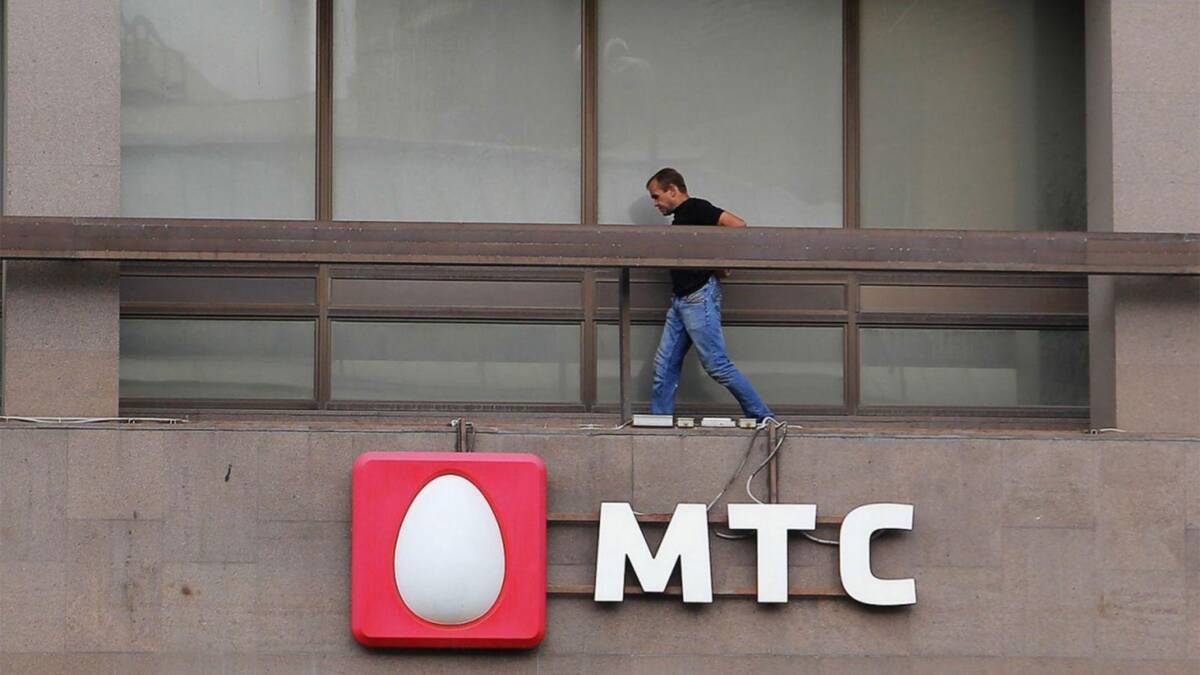 МТС получила лицензию на использование 5G 3 Человек на крыше здания с логотипом МТС установка 5G связи