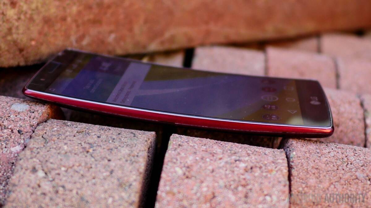 Смартфон LG K31 лежит на кирпичной поверхности, боковой ракурс