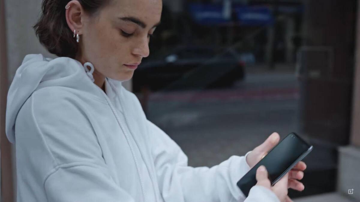 Раскрыт дизайн OnePlus Nord 5 Женщина в белой толстовке использует смартфон Samsung