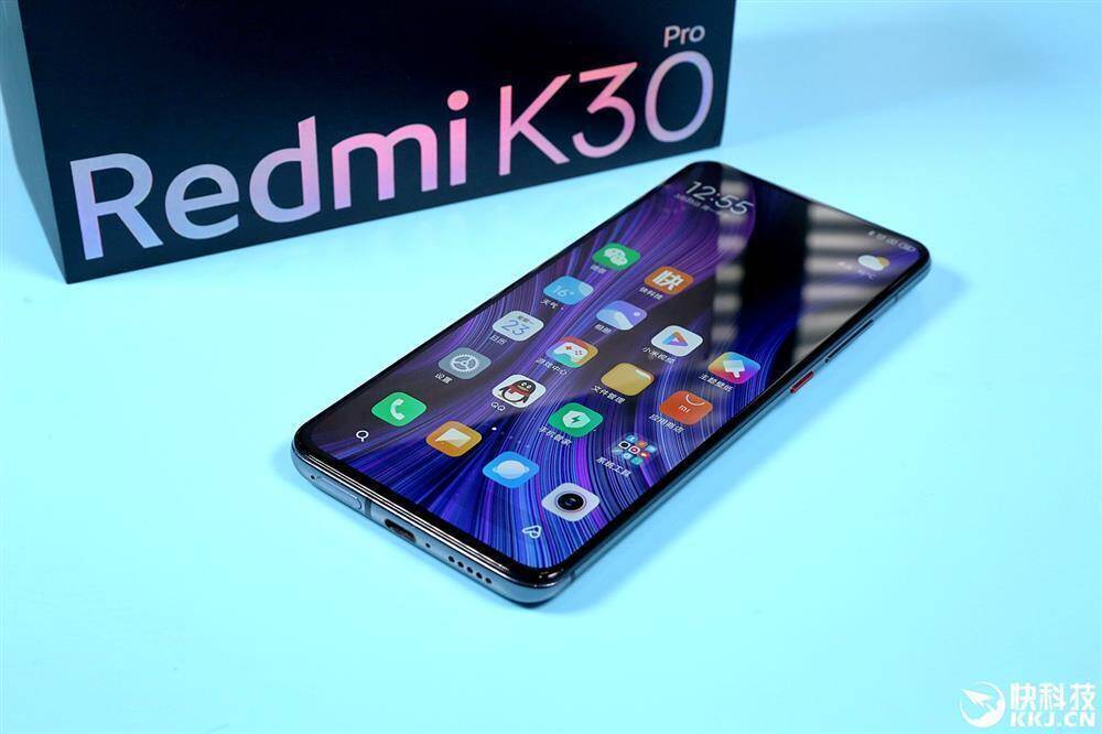 Смартфон Redmi K30 Pro на плоской поверхности дисплей ярко отображает иконки приложений