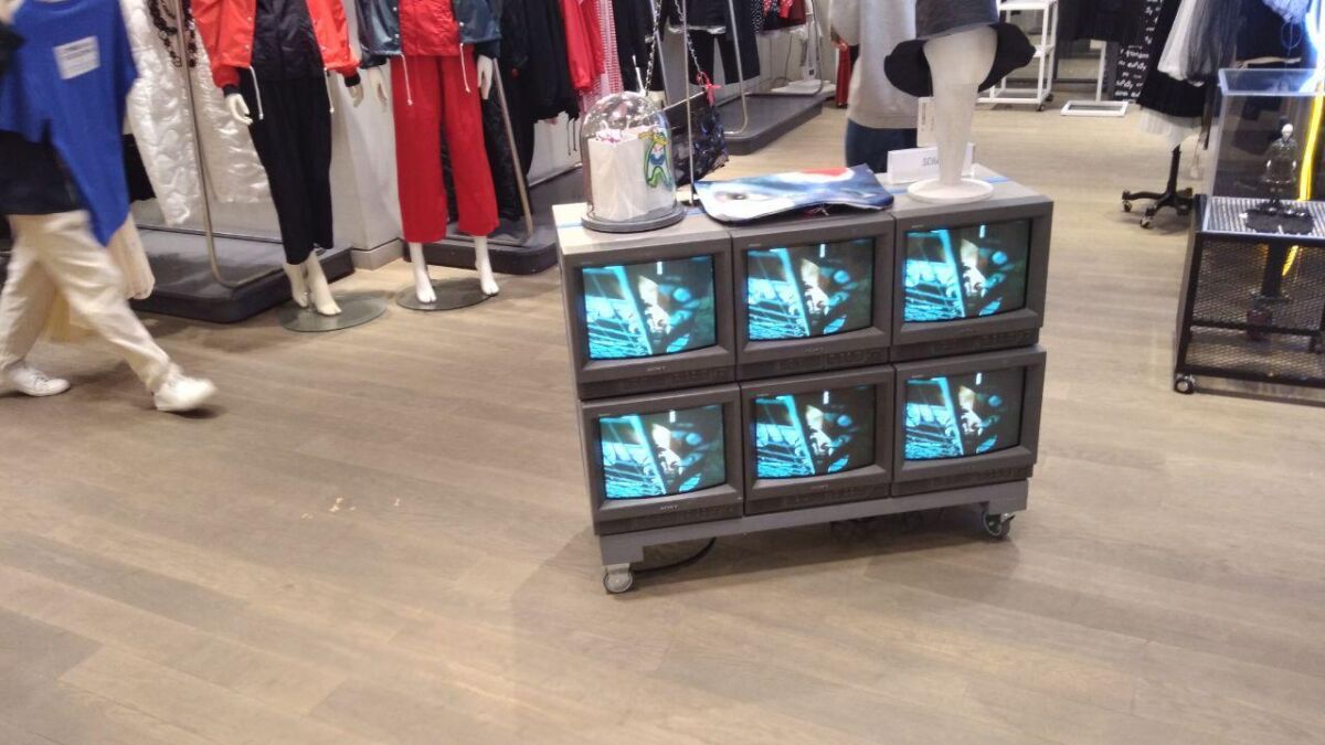 Экраны с изображением и магазинная витрина с одеждой рядом