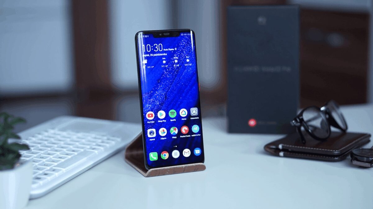 Умный телефон Huawei на зарядной подставке на рабочем столе