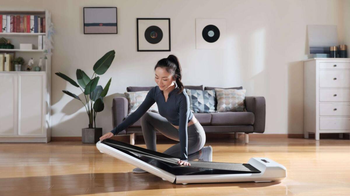 Девушка занимается на складной беговой дорожке WalkingPad S1 в гостиной