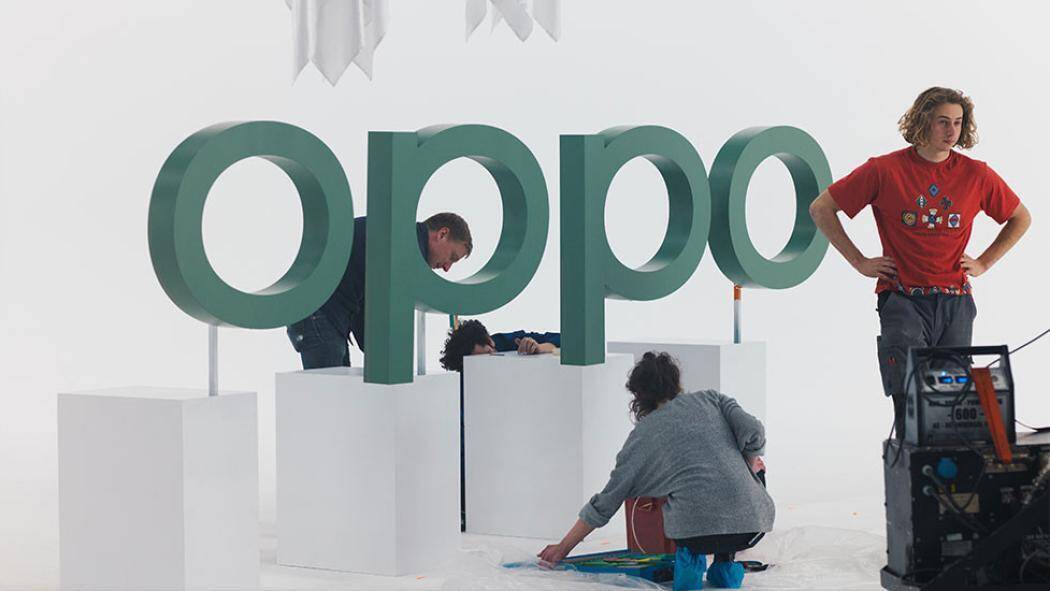 Большой знак OPPO в фоновом режиме с рабочей группой людей