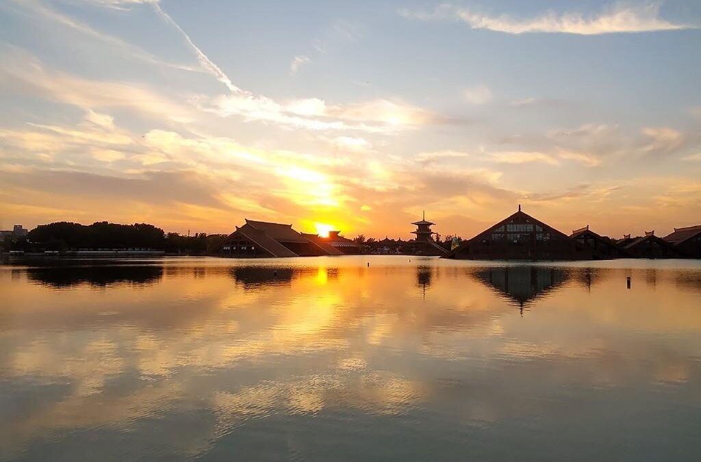 Рассвет над озером с отражением неба и зданий