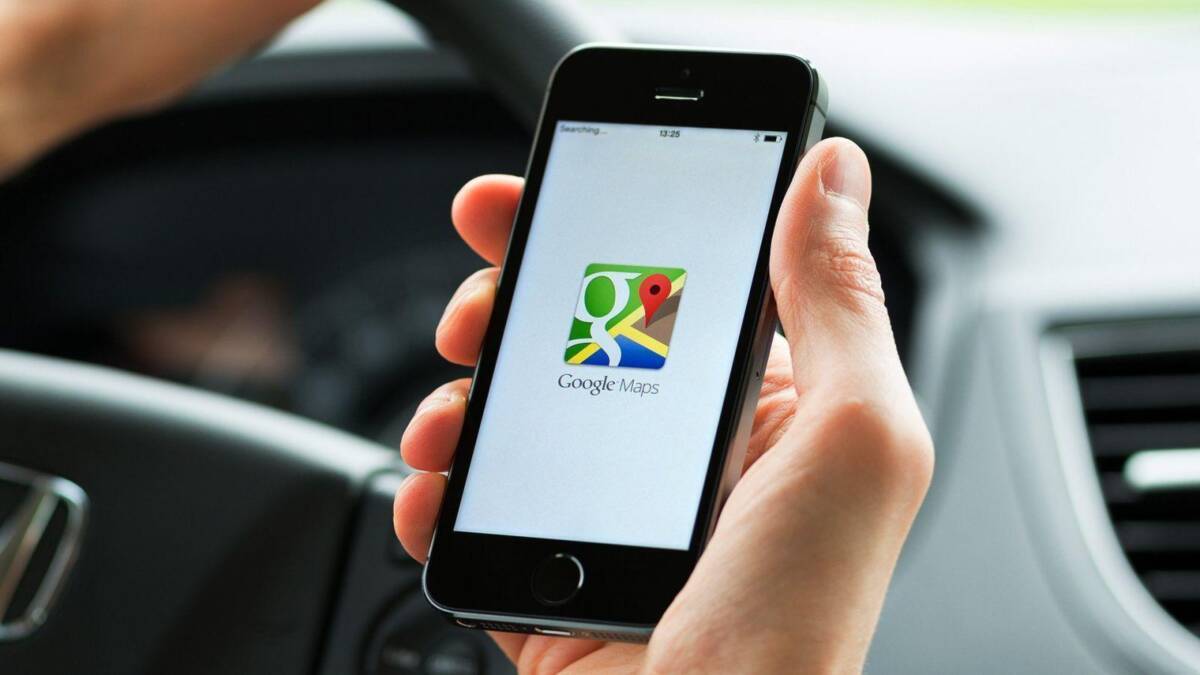 Мобильный телефон с приложением Google Maps на экране в авто