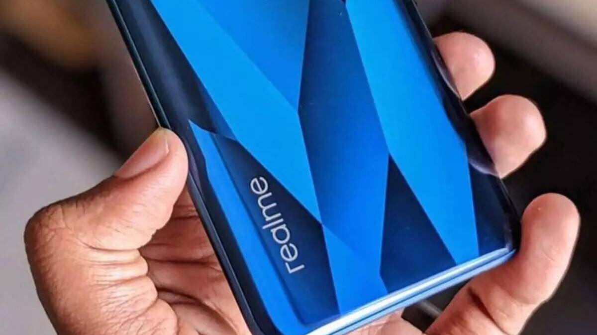 Рука держит смартфон Realme с экраном и логотипом
