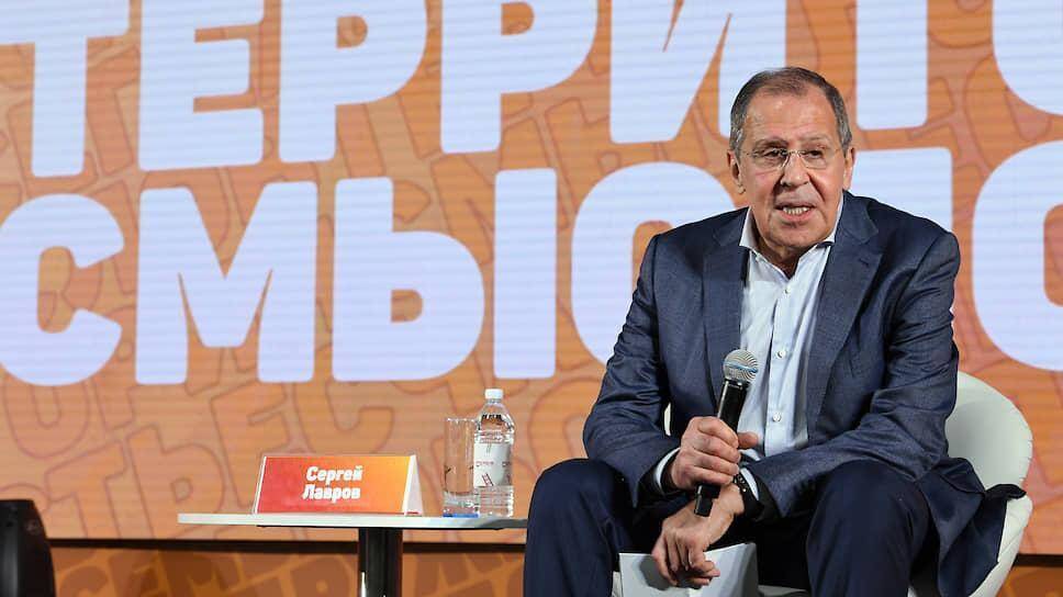 Сергей Лавров держит микрофон во время выступления на конференции