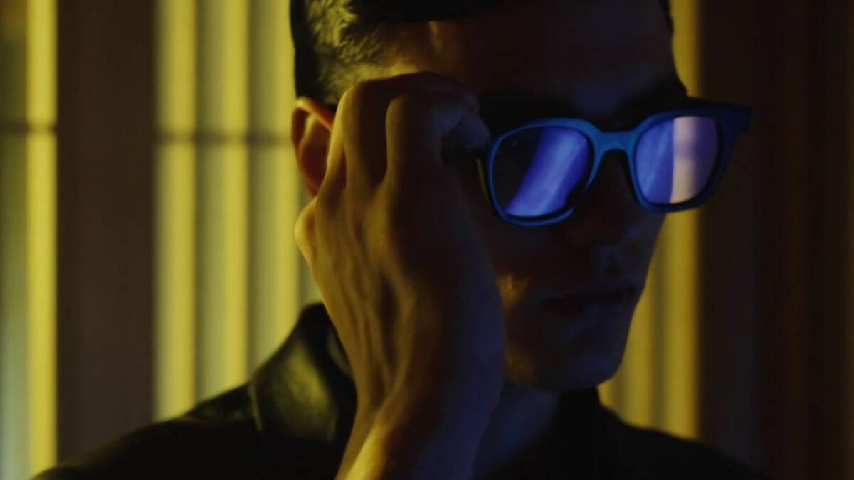 Человек в темных очках Huawei x Gentle Monster на лице на заднем плане лампы