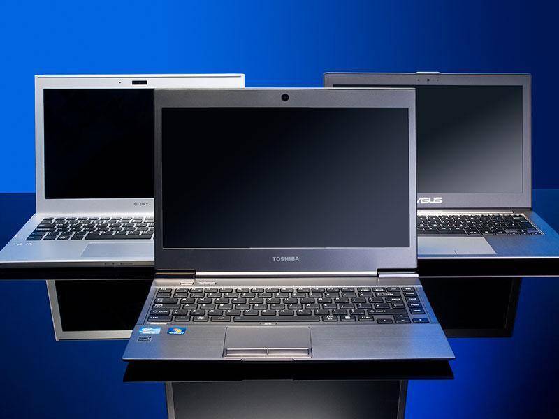 Ноутбуки Toshiba и ASUS на столе с темным фоном