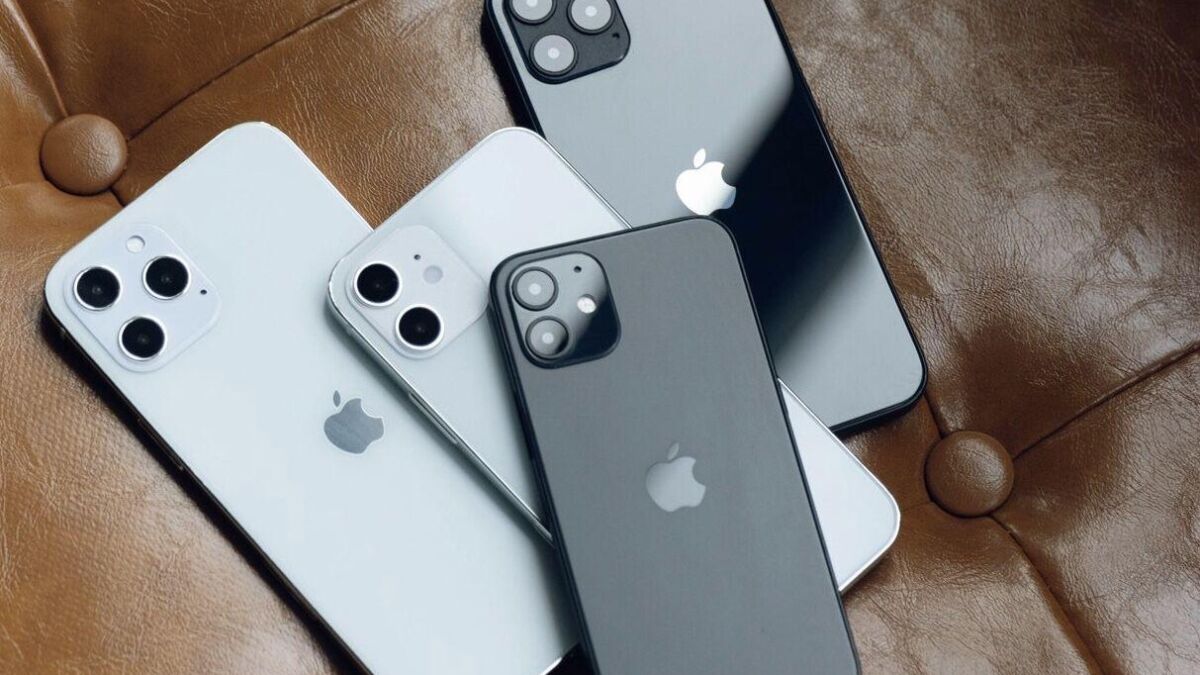 Четыре iPhone 12 с разными цветовыми оттенками на коричневой поверхности