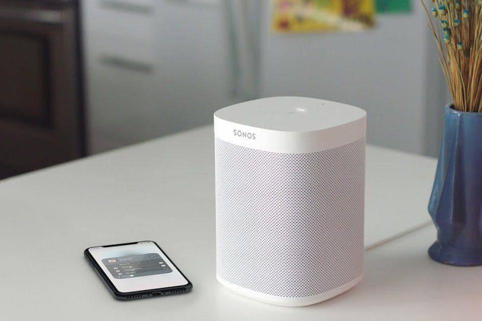 Sonos подает в суд на Google за нарушение 5 патентов на беспроводное аудио 5 Беспроводной колонка Sonos на белом столе и смартфон с настройками