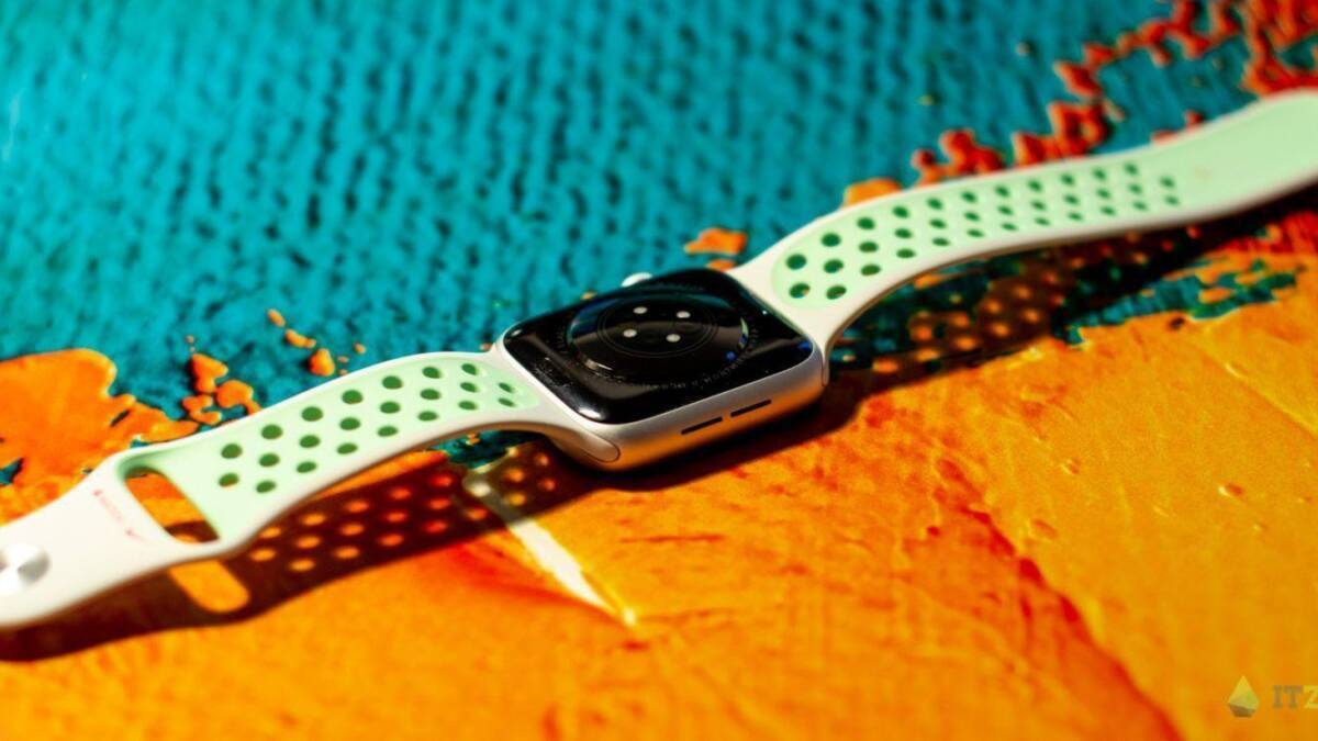 Умные часы Apple Watch с зеленым ремешком на ярком фоне