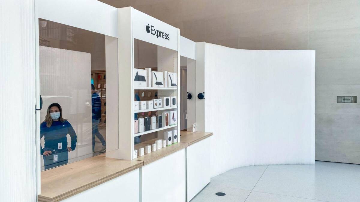 Apple тестирует экспресс-магазины для удобной выдачи онлайн-заказов 5 Витрина с товарами Apple Express и сотрудник в маске
