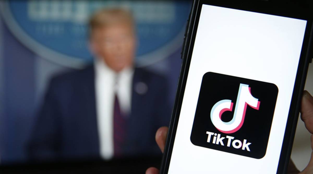 Телефон с логотипом TikTok на экране у человека