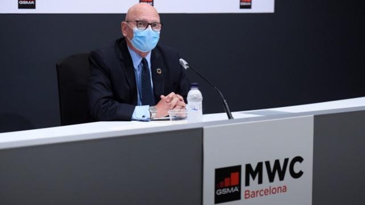 Бизнесмен в маске за столом на конференции MWC Барселона