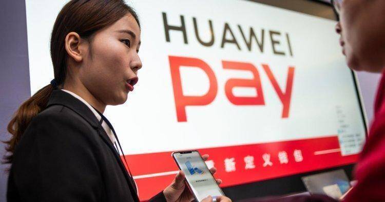 Девушка держит смартфон Huawei Pay на выставке