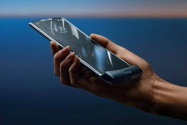 Смартфон Garmin в руке на фоне неба и воды