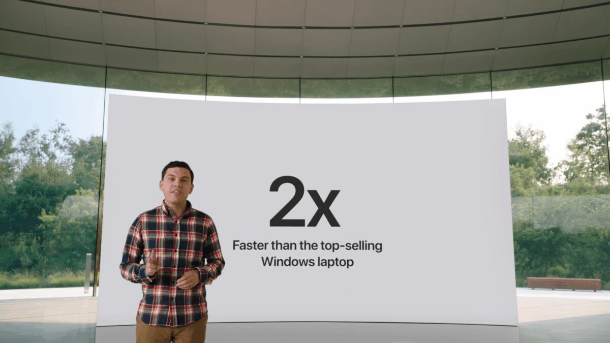 Мужчина показывает рекламный слайд с текстом о MacBook