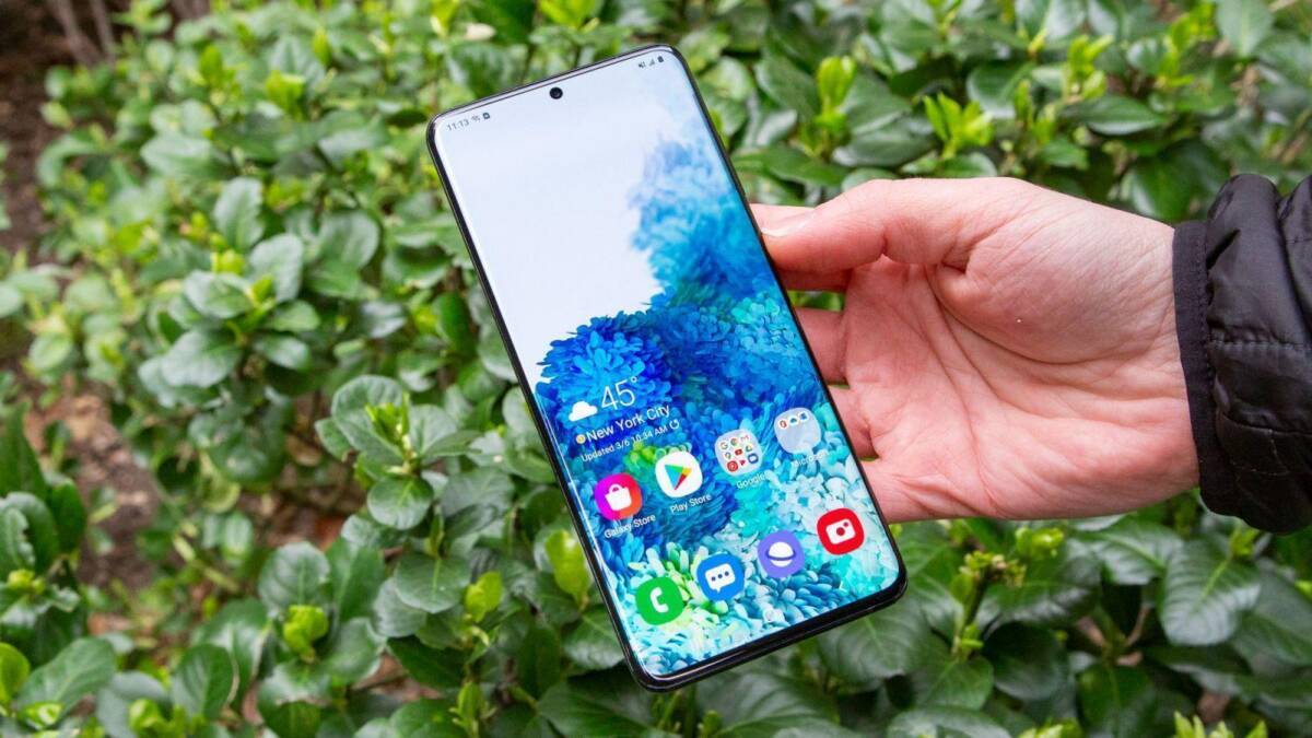 Смартфон Samsung Galaxy S20 FE в руке на улице
