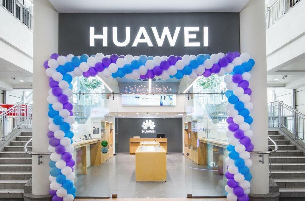 Вход в магазин Huawei украшен воздушными шарами фиолетового и голубого цветов здание с лестницами по обе стороны стеклянные двери