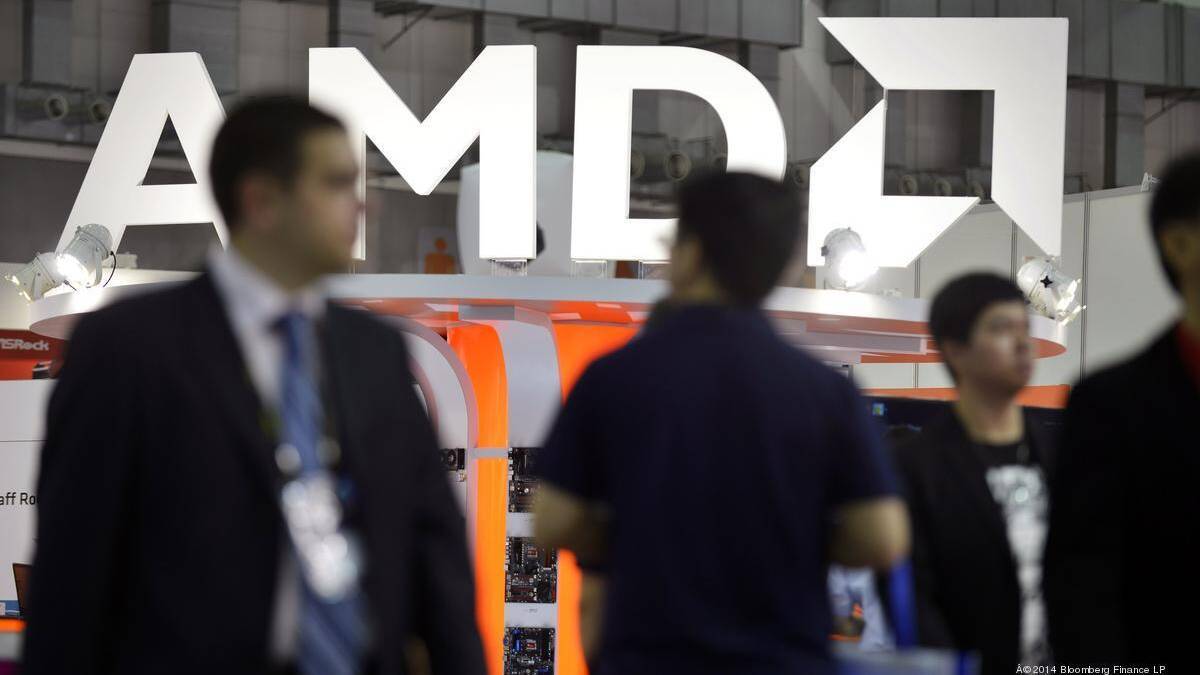 Логотип AMD на выставке с посетителями вокруг