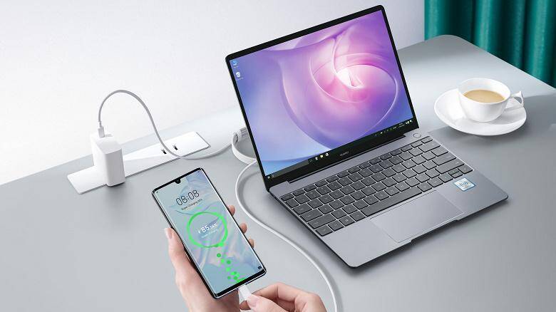 Ноутбук HUAWEI MateBook X подключен к зарядке на столе