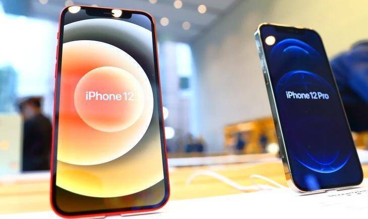 Два iPhone 12 и iPhone 12 Pro на дисплеях показывают название