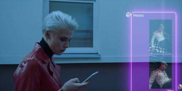 Девушка с серебристыми волосами смотрит на смартфон с голографическими интерфейсами в темной комнате