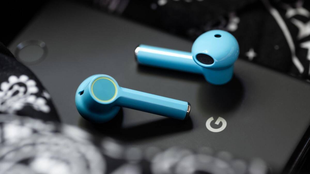 Беспроводные наушники OnePlus Buds Z голубого цвета на поверхности ноутбука