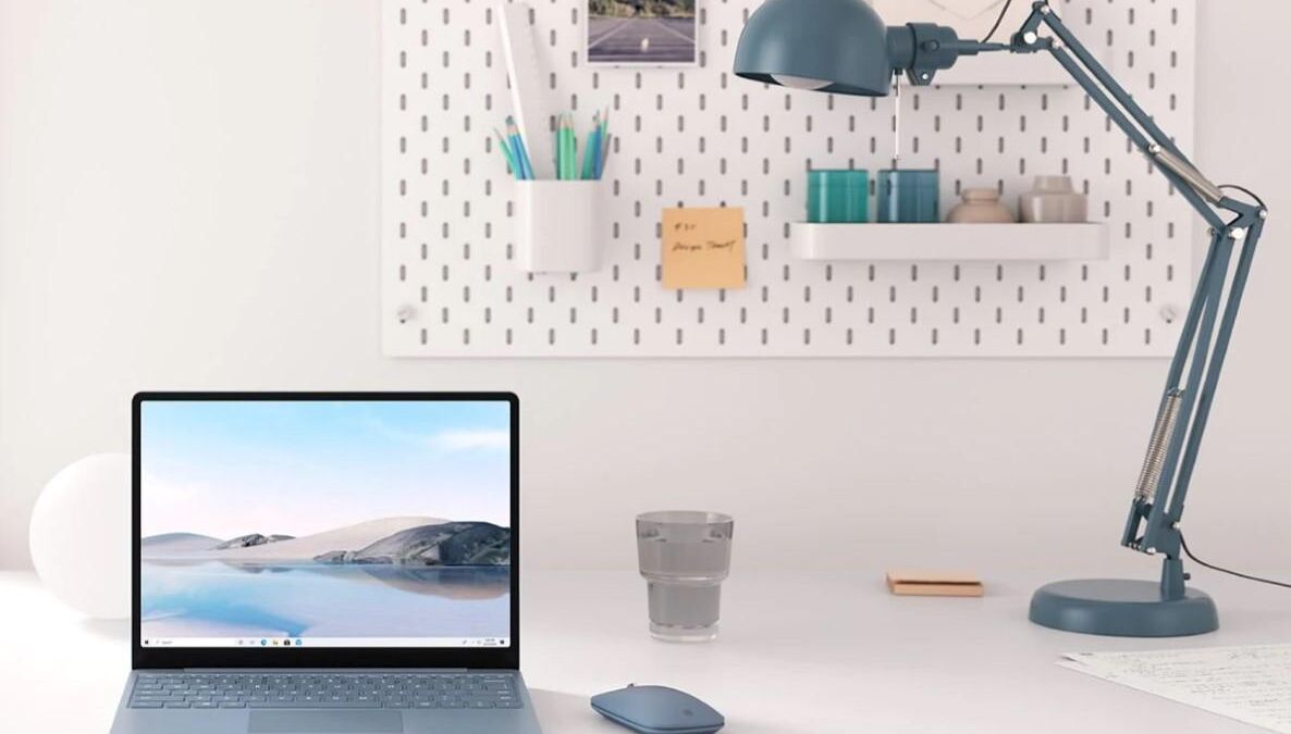 Ноутбук Surface Laptop Go с открытым экраном и мышью на столе