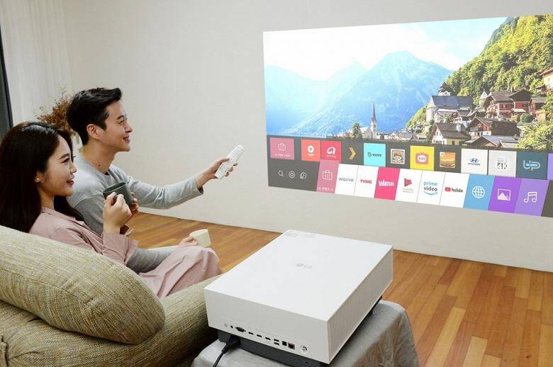 LG представила новый 4K-проектор за 3400 долларов 3 Два человека используют LG 4K-проектор в гостиной