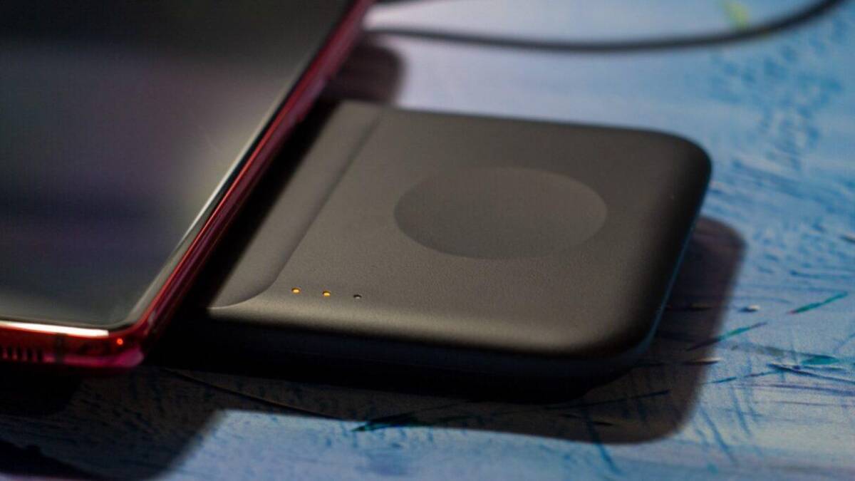 Смартфон OnePlus 9 Pro и беспроводное зарядное устройство на поверхности