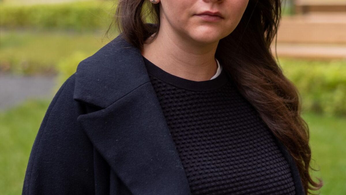 Женщина на улице с темной курткой и длинными волосами