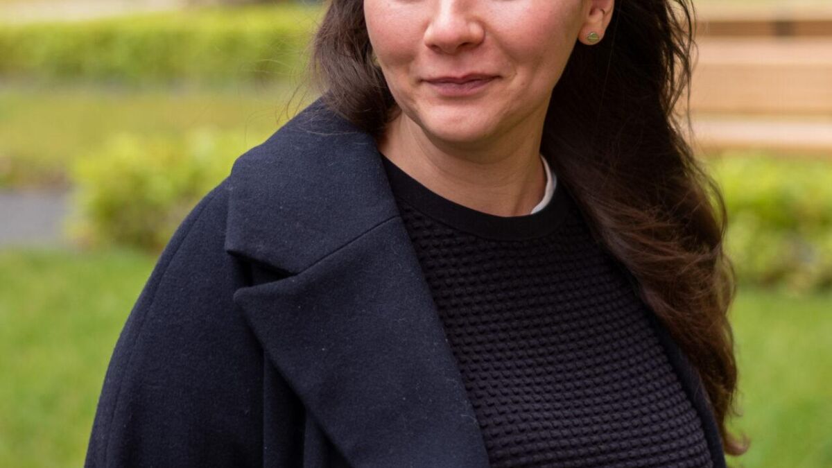 Женщина на улице с темной курткой и черной кофтой