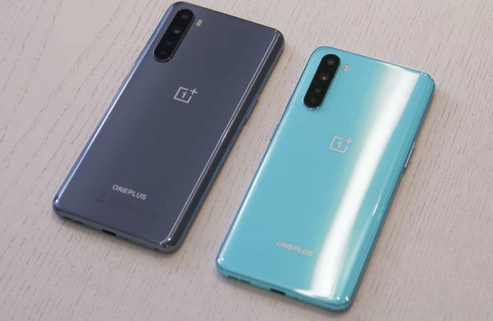 OnePlus Nord SE дебютирует в марте и получит зарядку на 65 Вт 4 Два смартфона OnePlus на светлом деревянном столе сзади и спереди задние крышки голубого и серого цветов разные камеры и логотипы OnePlus видны