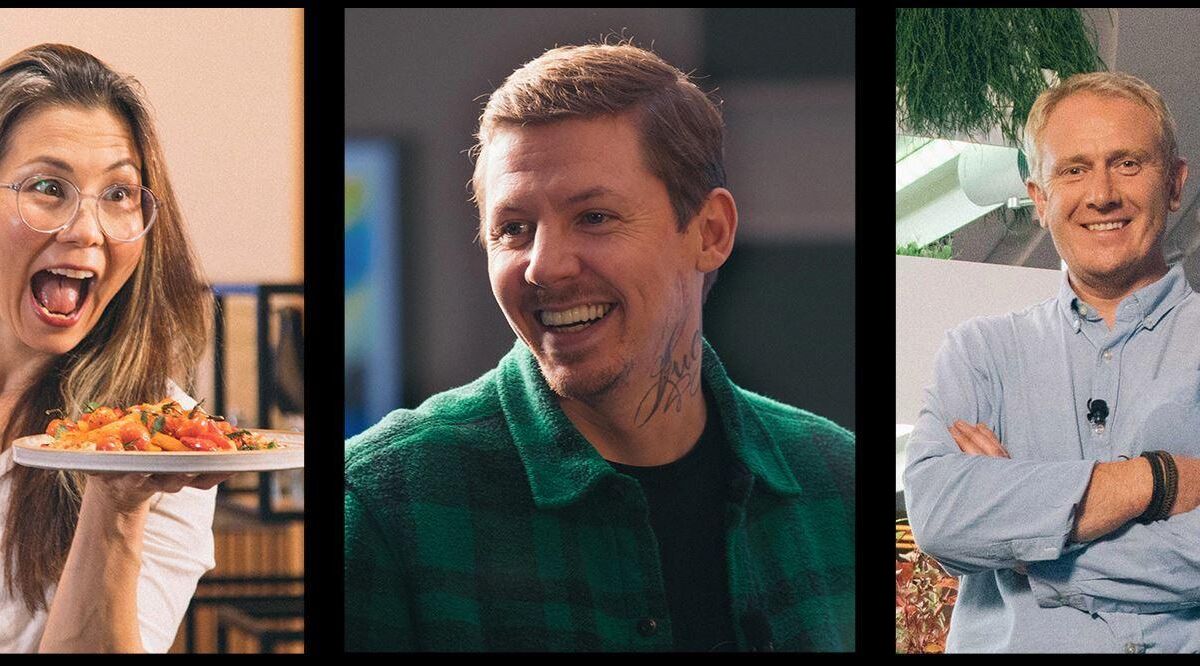 Три человека радостно улыбаются и общаются в помещении