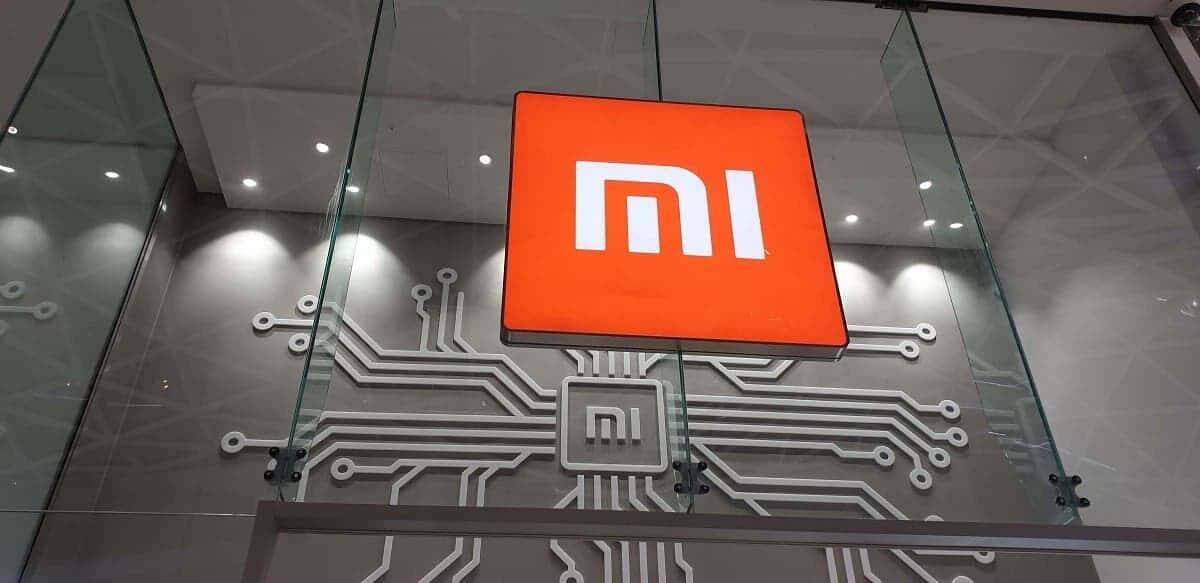 Xiaomi наймёт рекордное количество инженеров, несмотря на пандемию 4 Логотип Xiaomi на фасаде компании с технологическим фоном