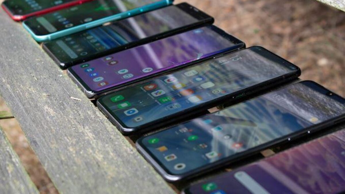 Несколько смартфонов на деревянной скамейке с экранами