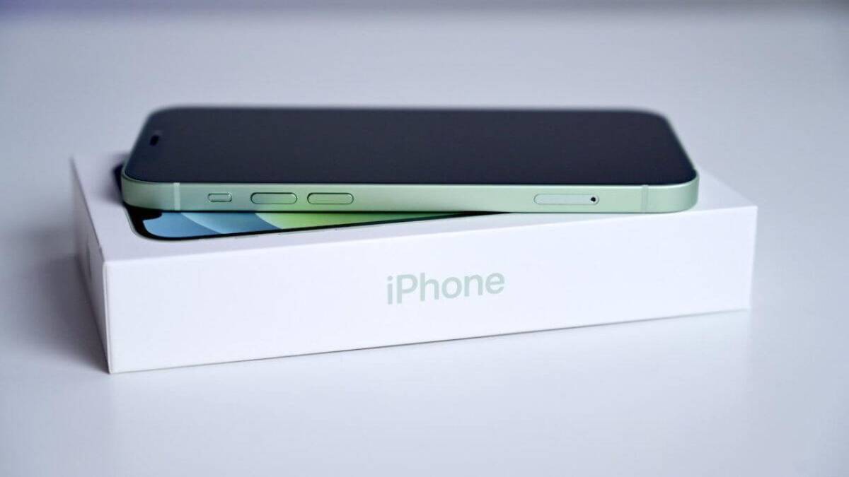 Черный iPhone 12 mini с зеленым краем на белой коробке