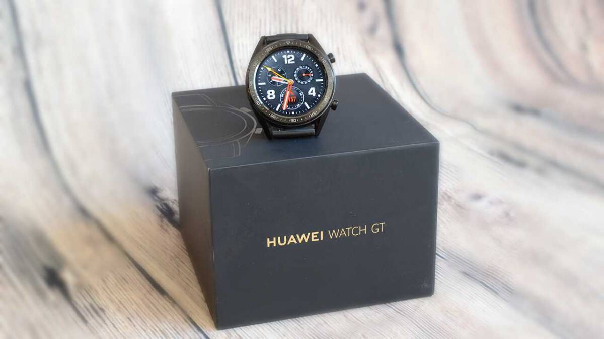 Умные часы Huawei Watch GT на черной коробке бежевого деревянного фона