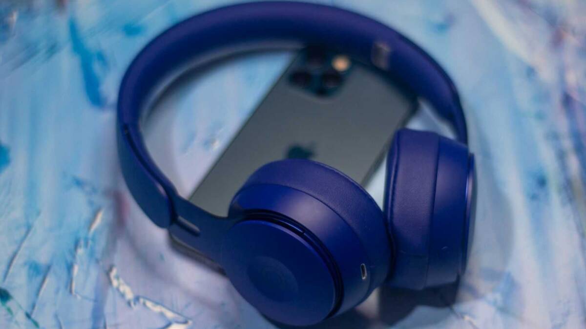 На изображении представлены наушники и смартфон Vivo X60 в черном цвете с синими наушниками