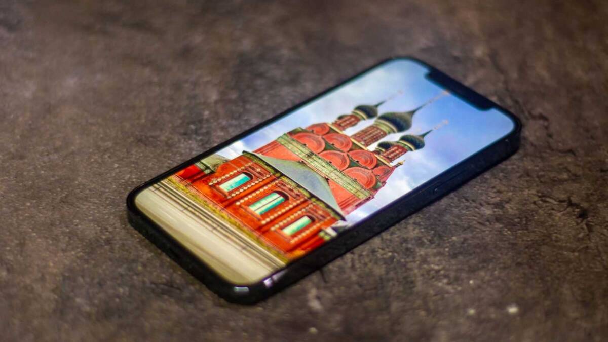 смартфон Redmi K40 на темном фоне дисплей с изображением красочного здания