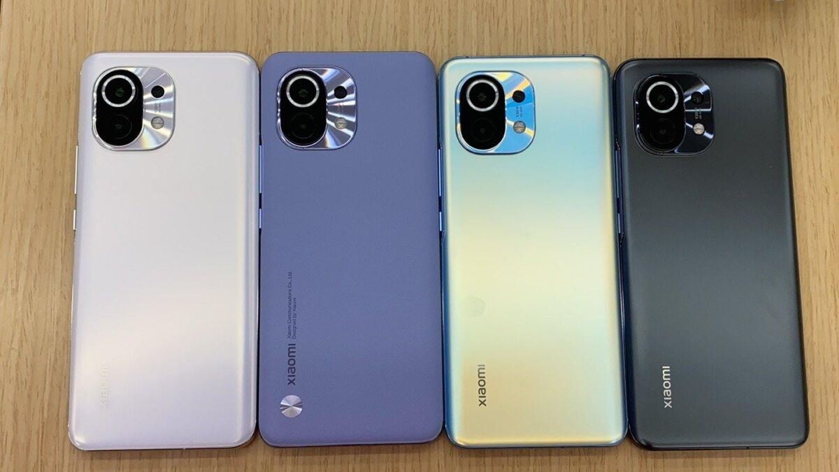 Четыре смартфона Xiaomi Mi 11 на деревянной поверхности