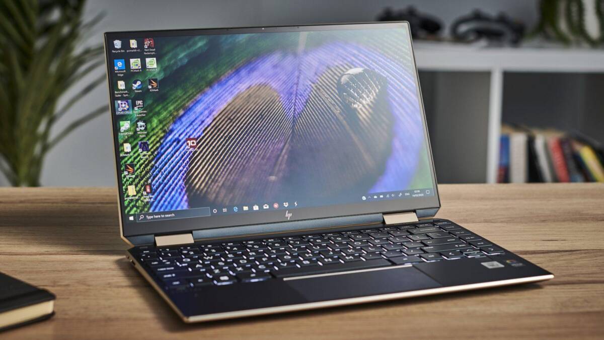 Ноутбук HP с раскрытым экраном на деревянном столе