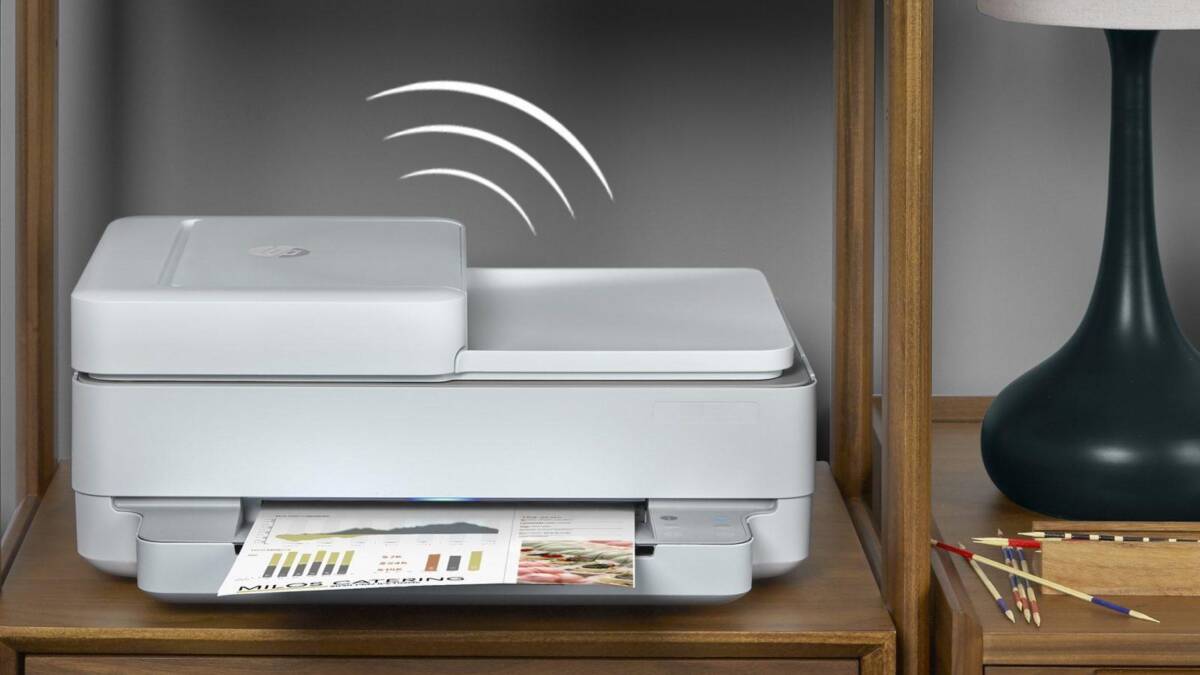 МФУ HP на деревянной тумбе рядом с лампой