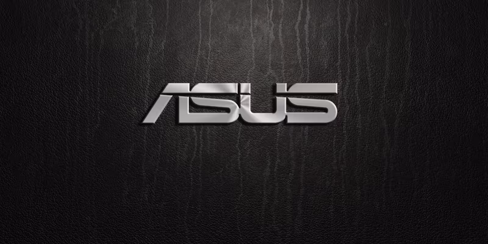 Металлический логотип ASUS на черной текстурированной поверхности, фон для анонса ноутбуков ASUS с AMD и NVIDIA