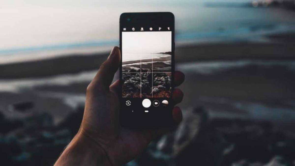 Мужчина снимает пейзаж на смартфон с Google Camera Go — природа в кадре