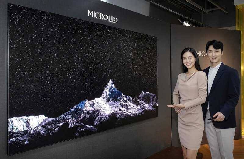Телевизор Samsung Micro LED TV 110 дюймов на выставке, рядом двое посетителей